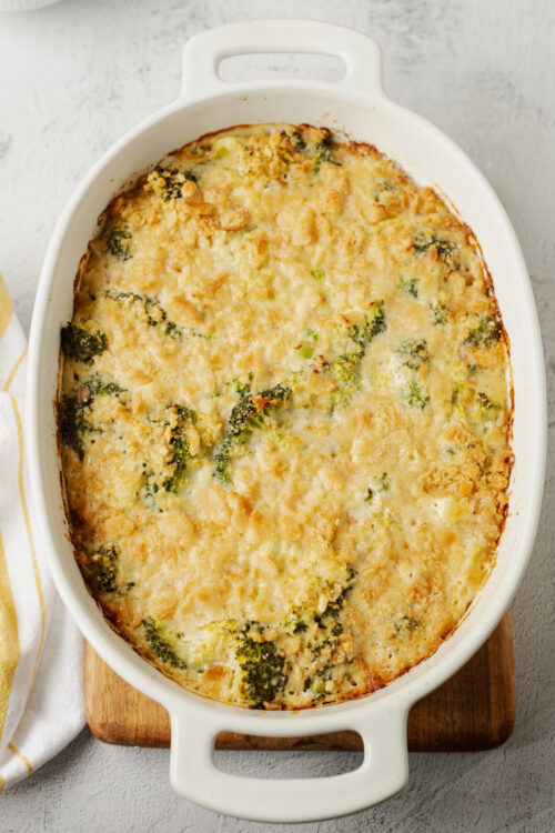 Creamy broccoli cauliflower casserole baked in a white dish with golden cheese topping.