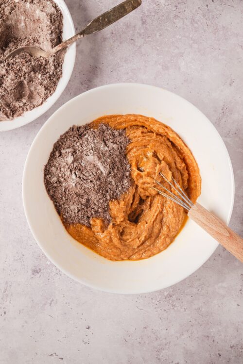 Creamy peanut butter cookie dough with cocoa powder in a white mixing bowl.