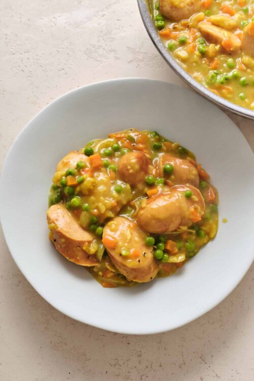Tender chicken and vegetables in a savory gravy served on a white plate.