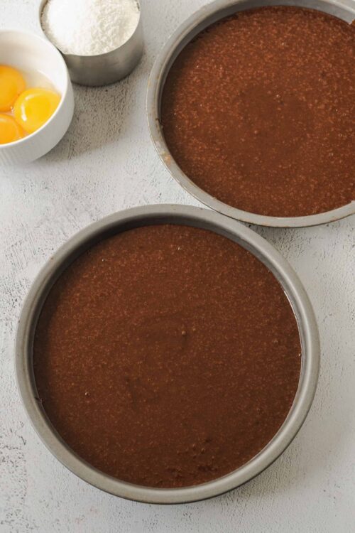 Rich chocolate cake batter in metal bowls for baking desserts.