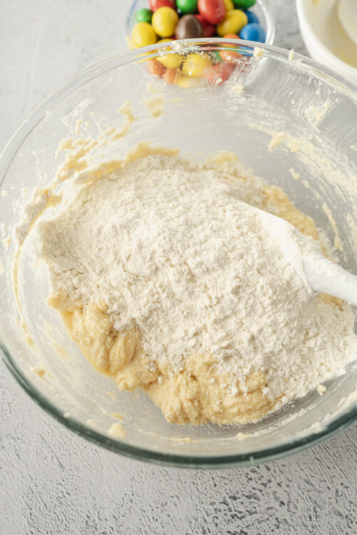 Flour added to mixing bowl with cookie dough for baking.