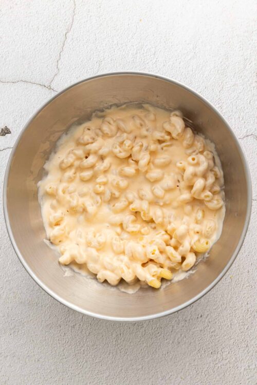 Creamy homemade macaroni and cheese in a stainless steel mixing bowl.
