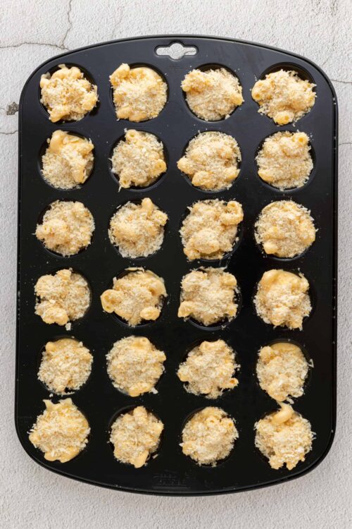 Buttery cookie dough balls in a black baking mold, ready to be baked into delicious treats.