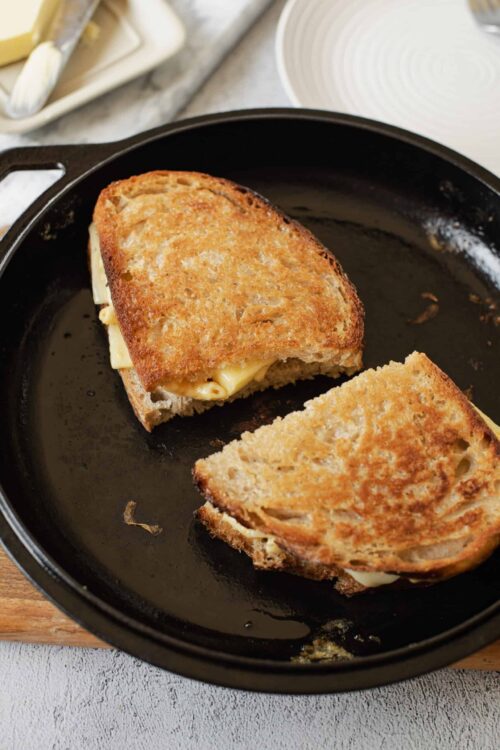 Golden brown grilled cheese sandwich in a cast iron skillet.