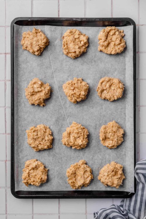 Freshly baked oatmeal cookie dough portions on a baking sheet.