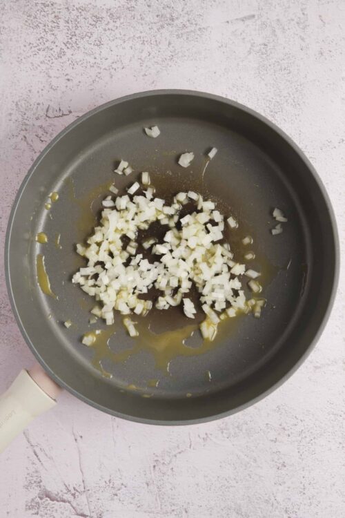 Chopped onions sautéing in a frying pan for easy cooking.