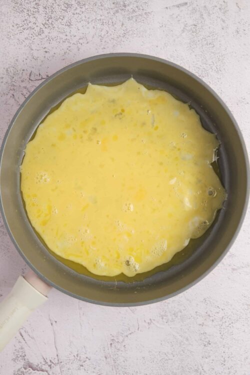 Fluffy scrambled eggs cooking in a non-stick skillet, perfect breakfast recipe.