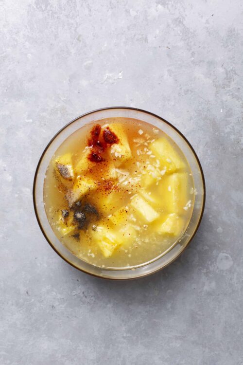 Cream of potato soup with spices in a glass bowl topped with paprika and black pepper.