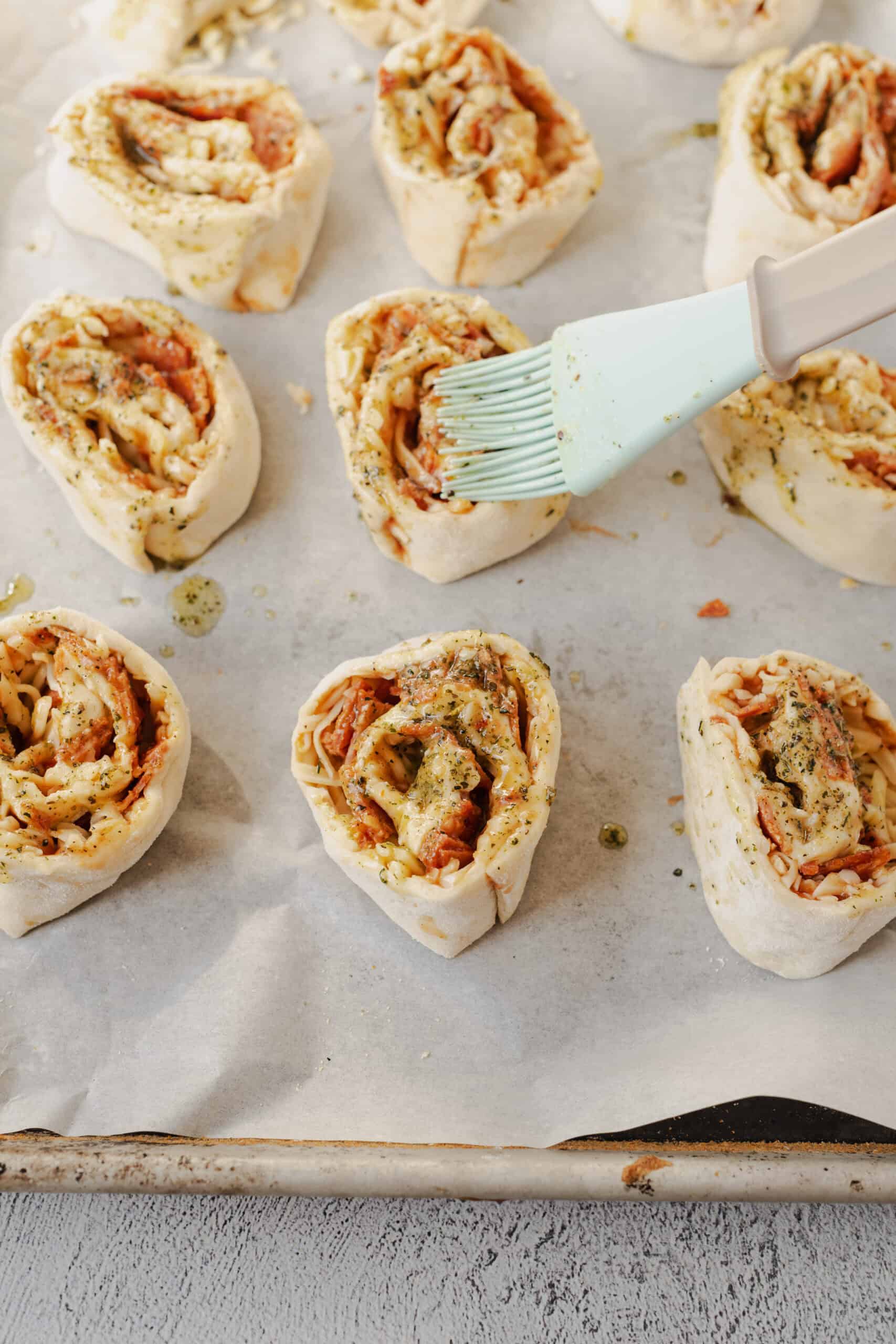 Pizza Rolls Recipe with ham, cheese, and herbs on parchment paper.
