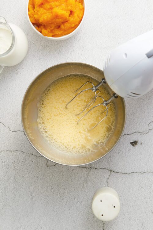Fluffy beaten eggs in a mixing bowl for baking or cooking.