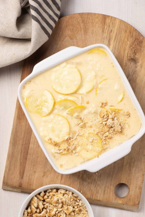 Creamy lemon dessert with sliced lemons and crushed cookies on top.