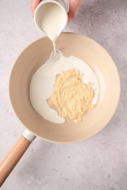 Cream being poured into a mixing bowl for baking.