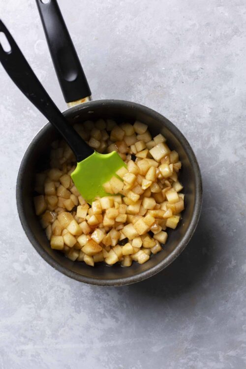 Golden diced apples cooking in a skillet for baking recipes.