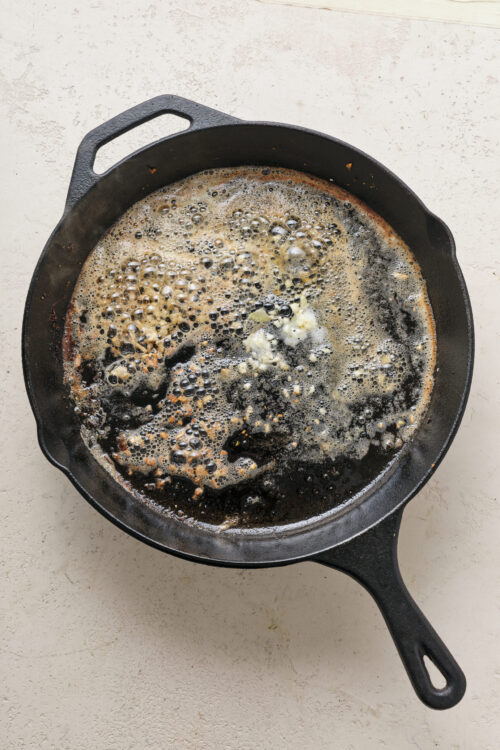 Sizzling butter in a cast iron skillet for baking or cooking.