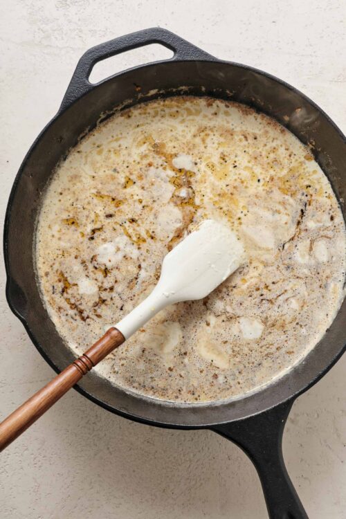 Creamy mushroom and garlic sauce simmering in a cast iron skillet.
