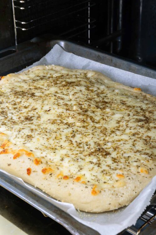 Cream cheese garlic bread with herbs baking in the oven, cheesy and perfectly seasoned.