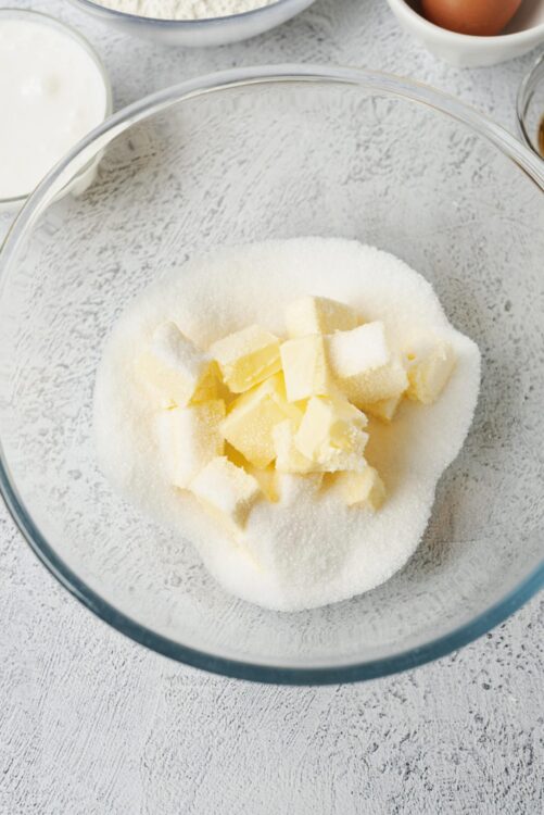 Flour, sugar, and butter in a glass mixing bowl for baking recipes.