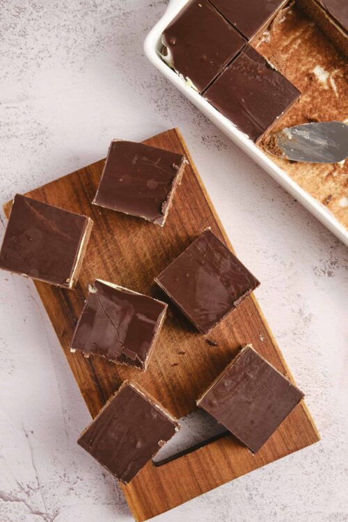 Rich chocolate fudge squares on a wooden board. Perfect for dessert or snacking. Easy homemade chocolate fudge recipe.