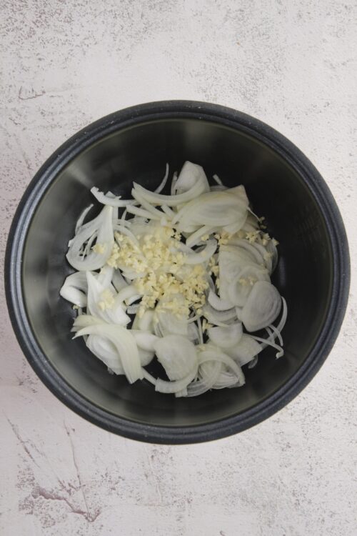 Sautéed onions with garlic in a pressure cooker for flavorful recipes.