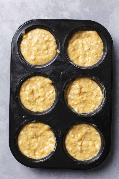 Creamy breakfast egg casserole mixture in a muffin tin for easy baking and serving.