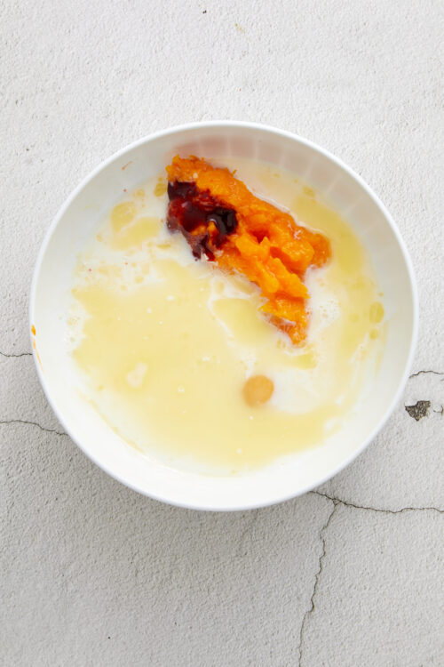 Creamy sweet potato casserole with caramelized topping and drizzles of syrup.