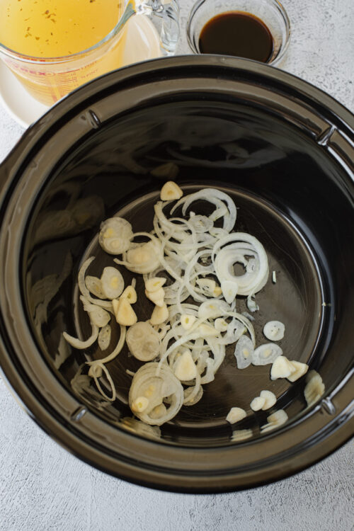 Sautéed onions and garlic in a slow cooker for flavorful recipes.