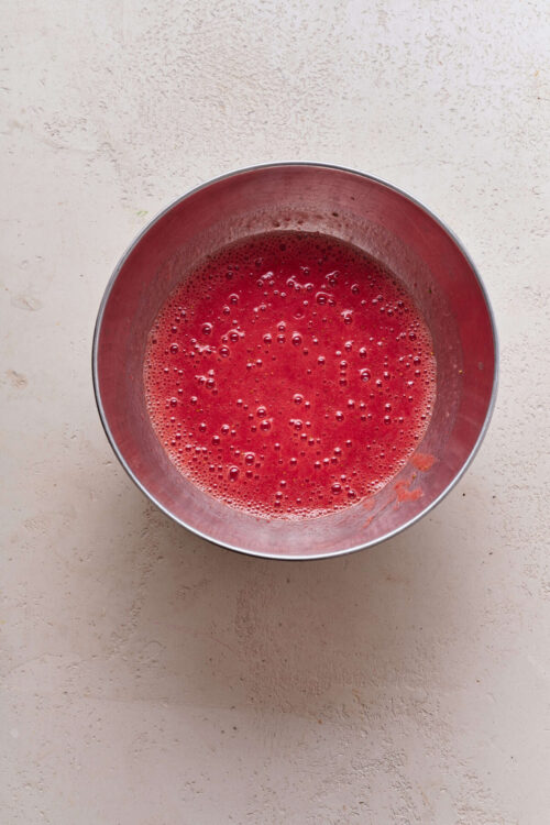 Freshly blended strawberry juice in a metal bowl, perfect for smoothies and healthy drinks.