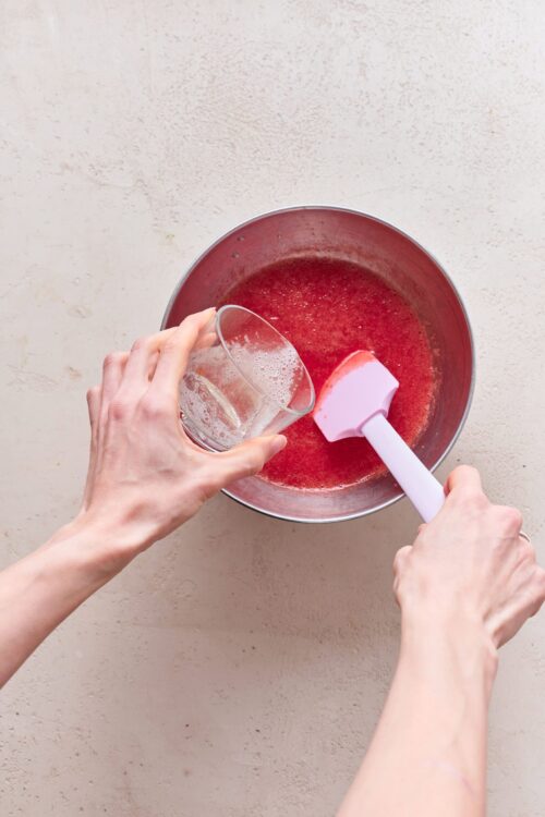 Fresh strawberry puree being prepared in a mixing bowl for baking or dessert recipes.