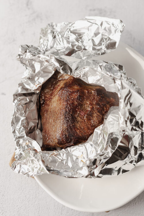 Juicy baked beef roast wrapped in aluminum foil, ready for serving or additional cooking.