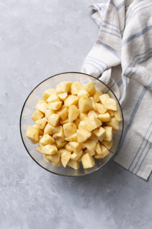 Diced fresh apples in a glass bowl for baking or cooking recipes.
