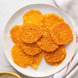 Crispy cheese crackers on a white plate, golden and crunchy, perfect for snacking or baking inspiration.