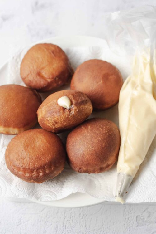 Golden brown hush puppies served with creamy white dipping sauce. Perfect for snacks or parties.