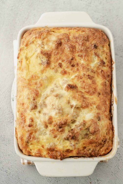 Creamy baked lasagna with melted cheese and savory meat sauce in a white casserole dish.