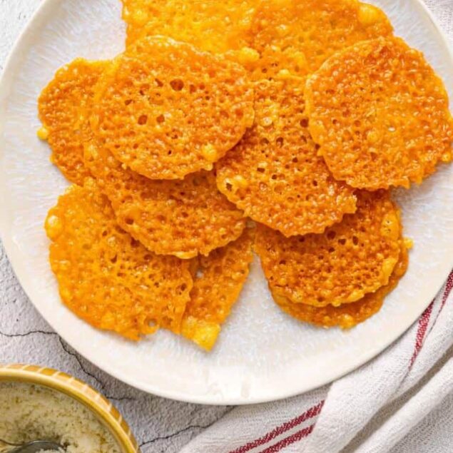 Crispy cheese crackers on a white plate, golden and crunchy, perfect for snacking or baking inspiration.