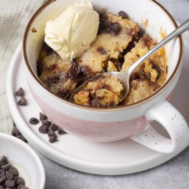 Warm chocolate chip cookie skillet topped with vanilla ice cream, perfect for dessert lovers.