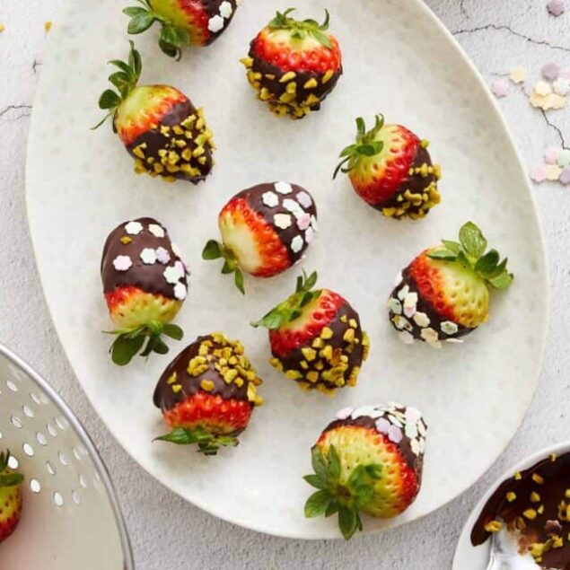 Fresh strawberries dipped in chocolate and topped with chopped pistachios and pastel sprinkles.