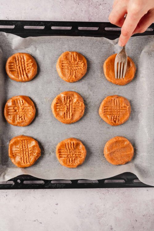 Soft peanut butter cookies on baking sheet, ready to be baked.