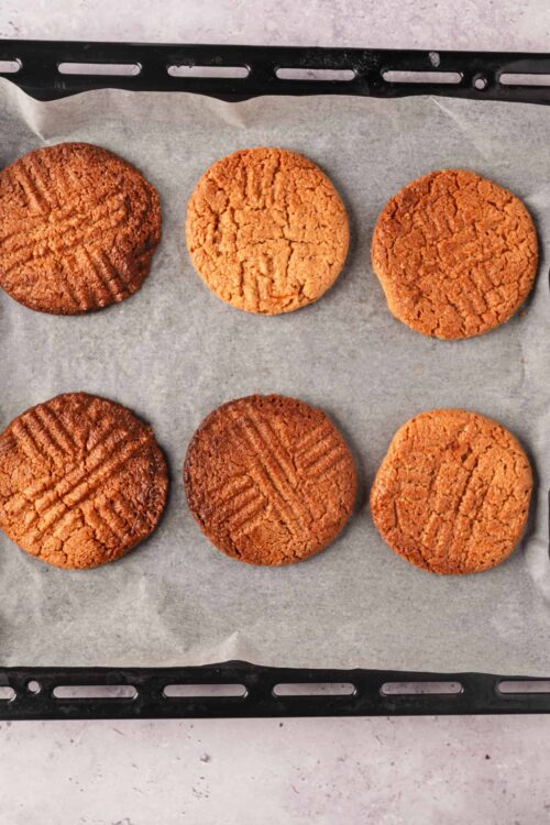 Butter pecan cookies on baking sheet with parchment paper.