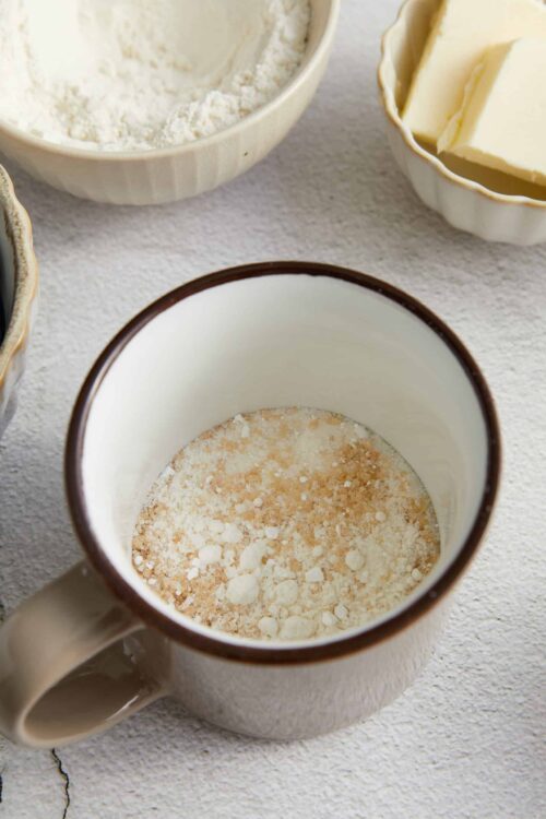 Flour and butter ingredients for baking on a textured surface.