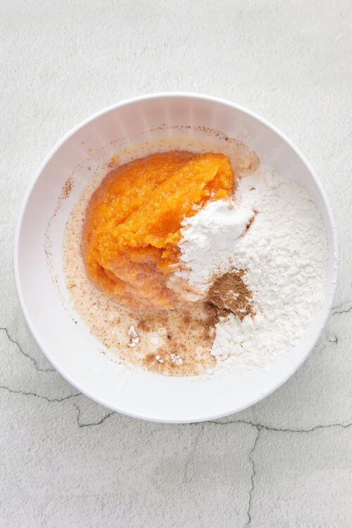 Sweet potato and spice baking ingredients in a white bowl for baking recipes.