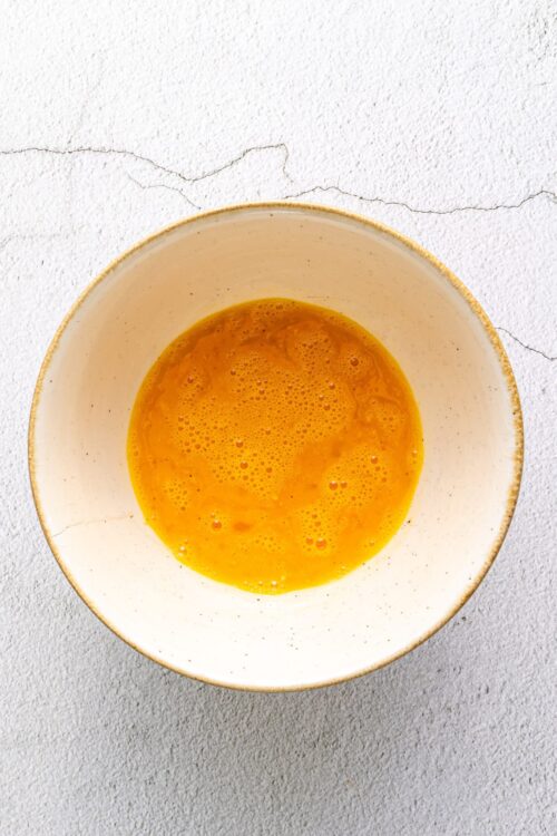 Creamy French toast batter in a rustic ceramic bowl, ready for breakfast or brunch. Ideal for delicious homemade pancakes or French toast recipes.