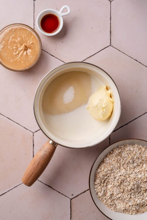 Creamy apple cinnamon oatmeal ingredients in a saucepan with oats, butter, and brown sugar.