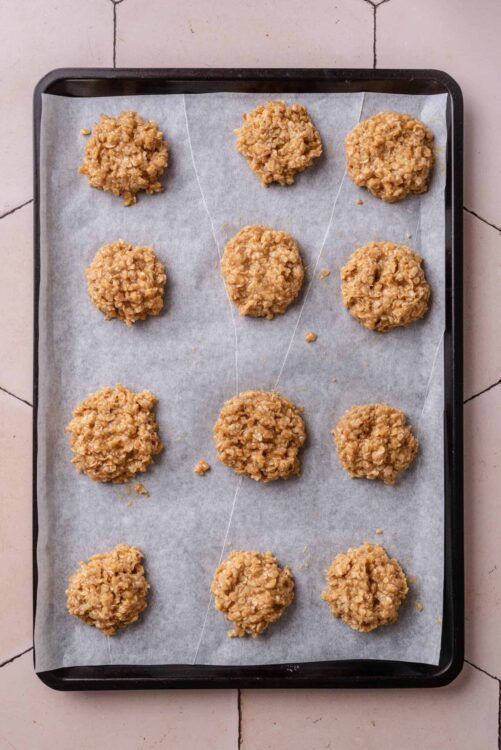 Soft oatmeal cookie dough balls on baking sheet before baking, homemade cookies preparation.