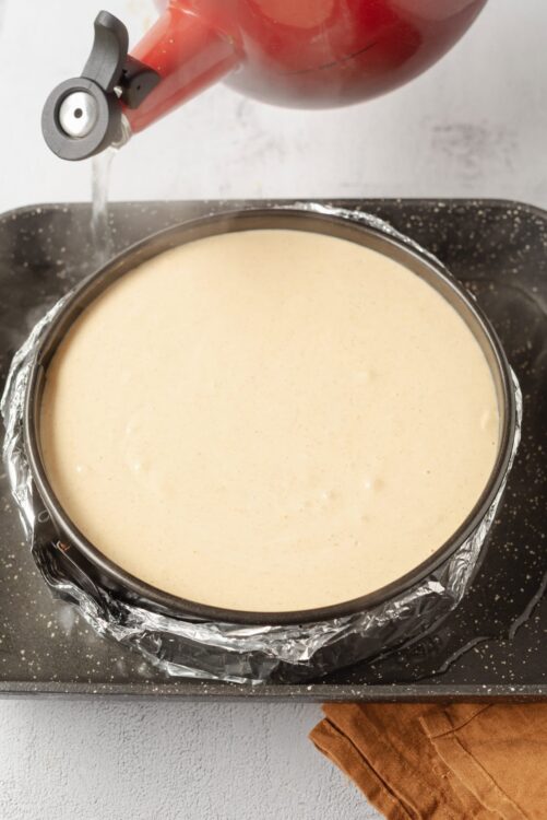 Creamy cheesecake batter cooling in a springform pan. Ideal for baking homemade cheesecake recipes. Perfect dessert for special occasions.