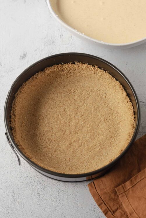 Golden graham cracker crust in a springform pan ready for baking.