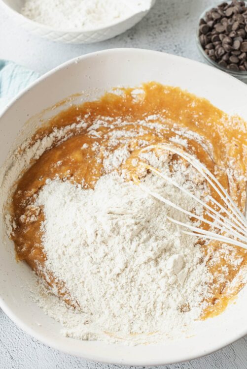 Flour and pumpkin mixture for baking in a white mixing bowl.