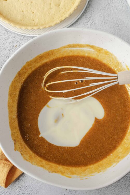Creamy tomato soup with a swirl of cream in a white bowl, ready to serve. Perfect for cozy homemade meals.
