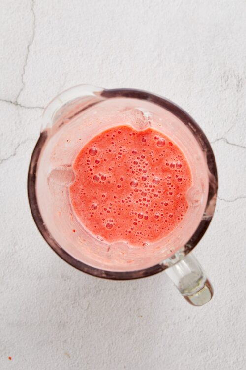 Freshly blended strawberry smoothie in a glass blender.
