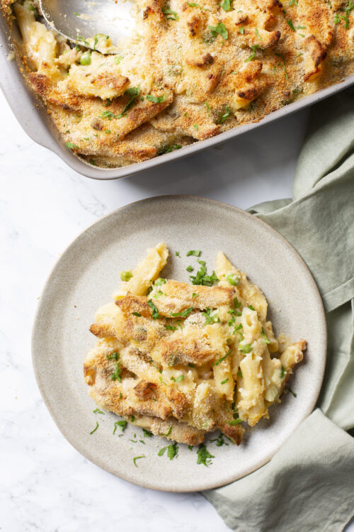 Buttered baked macaroni and cheese with breadcrumb topping in a casserole dish, served with parsley garnish.