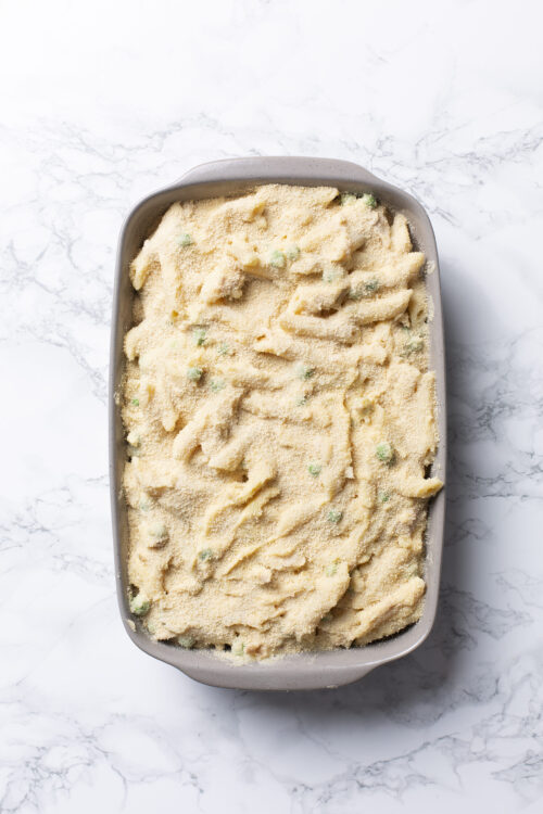 Butter pecan ice cream in a gray dish on a marble countertop.